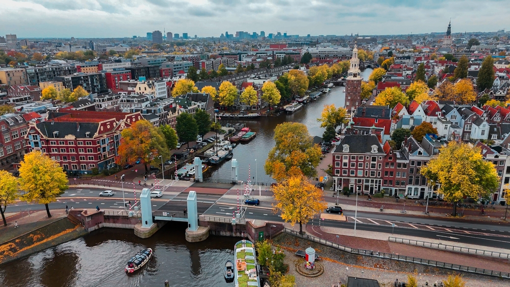 Luchtfoto van Amsterdam met grachten, een brug en bomen in herfstkleuren