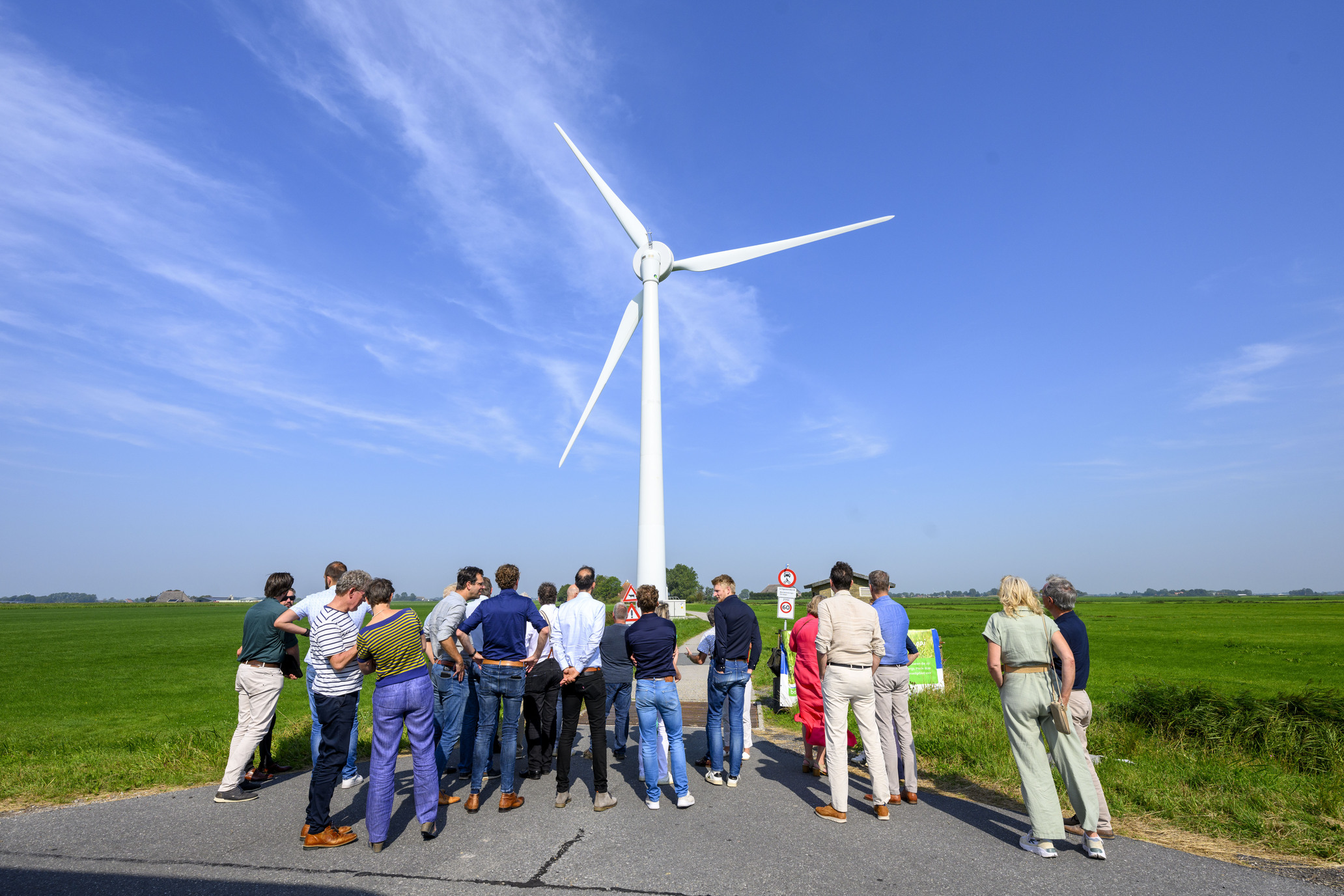 Een groep bezoekers bij een windmolen in het Friese landschap